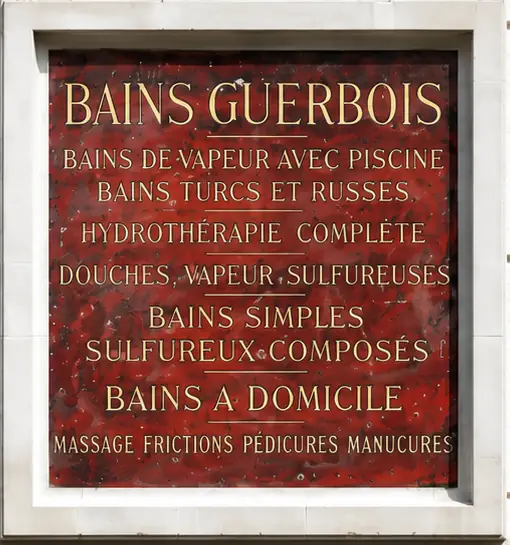 The marble plaque from the Les Bains Guerbois entrance steps, listing the different baths offered by the establishment.